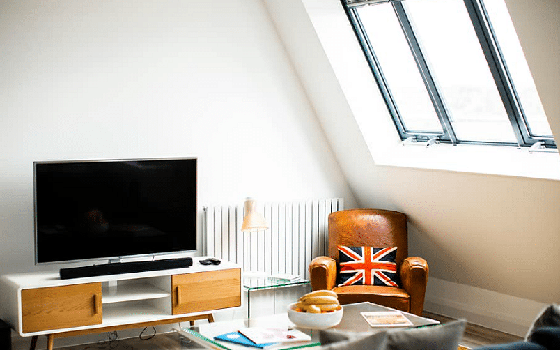 Loft living space, roof window with modern TV furnishing