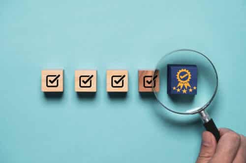 Hand holding magnifier glass to focus the best quality assurance