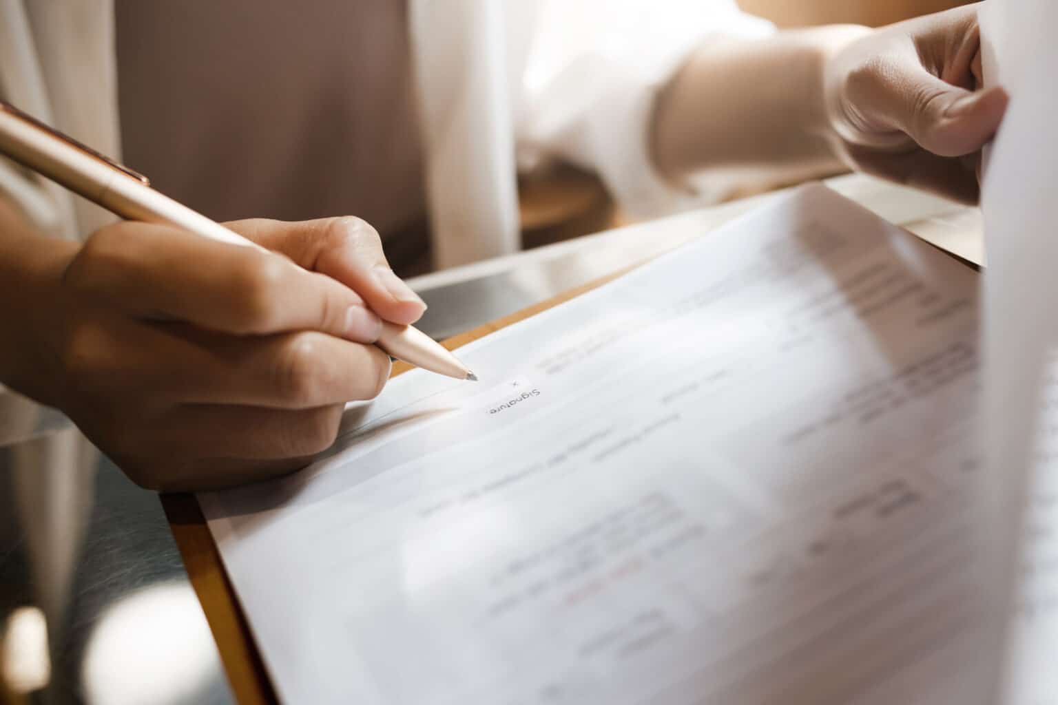 Focus on persons hand signing house documents